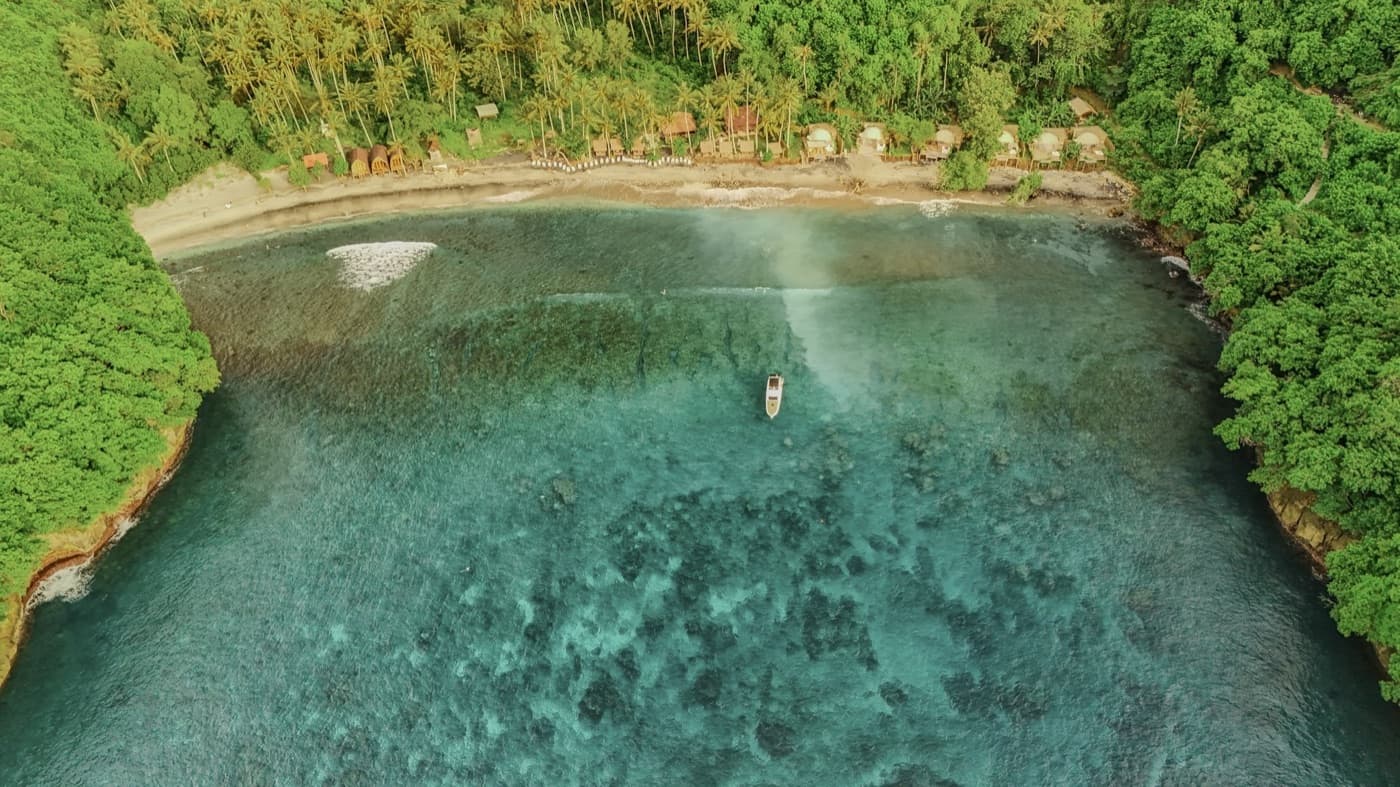 Aerial view of Gamat Bay's turquoise waters and coral reef on Nusa Penida